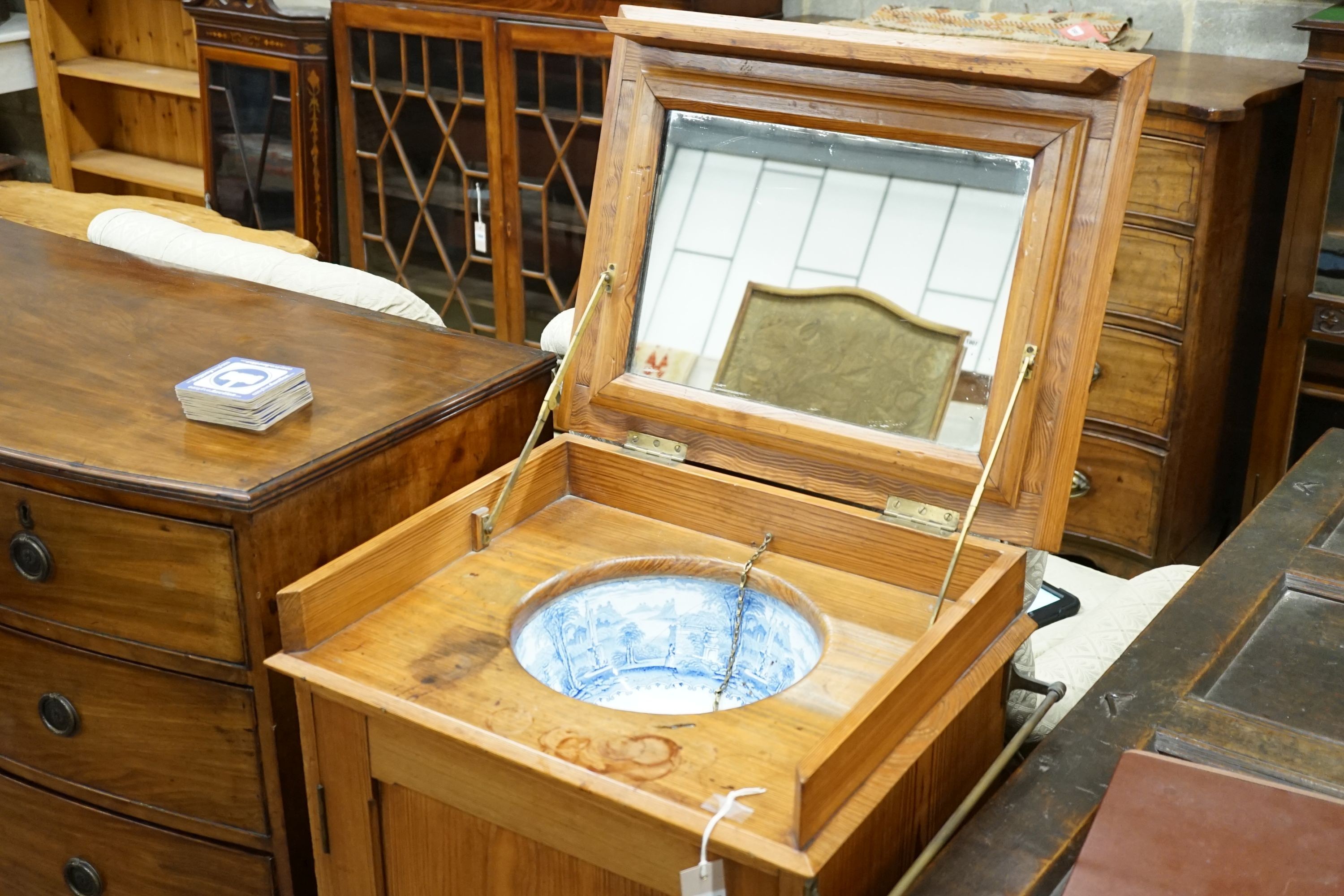 A late Victorian pitch pine wash stand with mirrored folding lid and blue and white printed basin (a.f.), width 58cm
